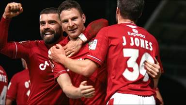 A group of men in red jerseys hugging

Description automatically generated